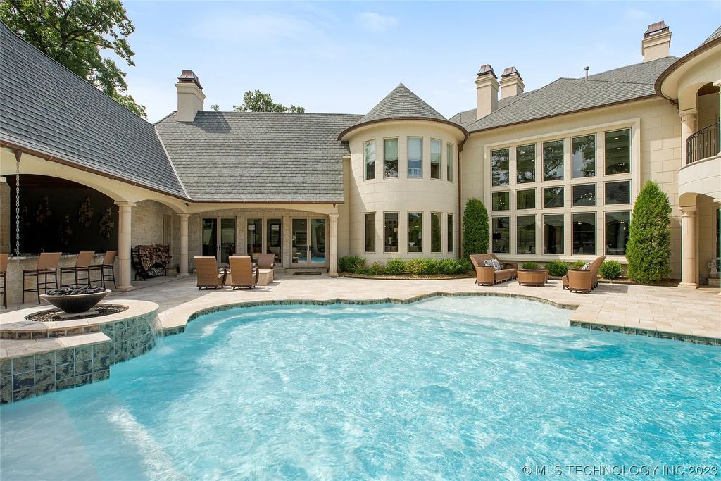 2411 E 34th Street Home in Tulsa, Oklahoma. Experience the epitome of luxury in this one-of-a-kind, majestic midtown mansion. Built in 2010, this stunning residence showcases high ceilings and bright, open rooms that overlook an incredible backyard oasis. Ideal for entertaining, the home features multiple game rooms, a theater, two gyms, a billiards room, and a cigar lounge with ventilation to the outside. Indulge in the 1,000-bottle wine room, relax by the spacious pool and spa, and enjoy outdoor dining with the convenient outdoor kitchen and covered living area.