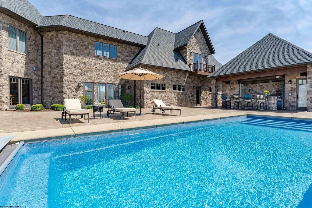 2536 Halleck Road Home in Morgantown, West Virginia. Discover the epitome of secluded luxury living with this sprawling estate nestled on 20+ acres of stunning West Virginia landscape. With over 9,500 square feet spread across three floors, this meticulously designed home offers 4 or 5 bedrooms, 5 full and 4 half bathrooms, and a refined color palette that sets the stage for elegant furnishings. The chef's kitchen features top-of-the-line Sub Zero and Wolf appliances, custom cabinetry, and a hidden walk-in pantry. 