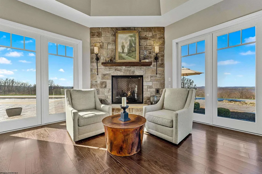 2536 Halleck Road Home in Morgantown, West Virginia. Discover the epitome of secluded luxury living with this sprawling estate nestled on 20+ acres of stunning West Virginia landscape. With over 9,500 square feet spread across three floors, this meticulously designed home offers 4 or 5 bedrooms, 5 full and 4 half bathrooms, and a refined color palette that sets the stage for elegant furnishings. The chef's kitchen features top-of-the-line Sub Zero and Wolf appliances, custom cabinetry, and a hidden walk-in pantry. 