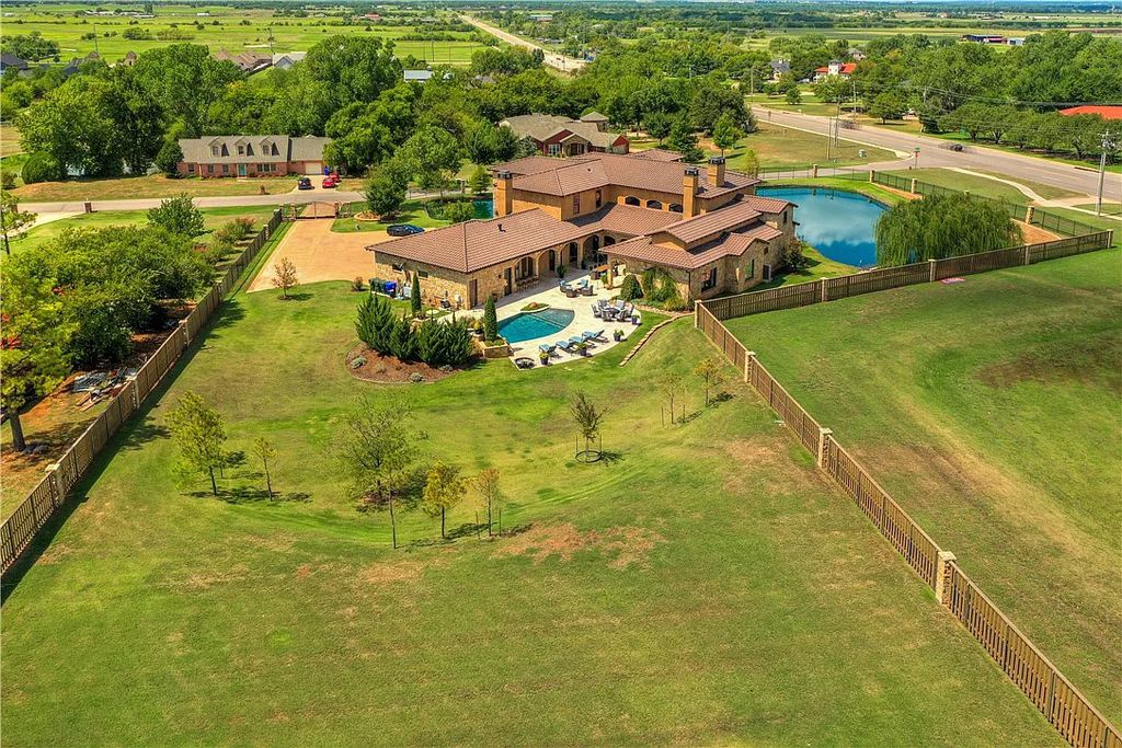 3507 Hillview Drive Home in Drive, Norman, Oklahoma. The home boasts picturesque views from the moment you approach it. Some of its exceptional features include a massive, aerated, and stocked pond that holds approximately 1 million gallons of water, premium finishes and appliances throughout, travertine flooring, two laundry rooms, rare and unique granite, 10-foot garage doors, a hydraulic elevator, spray foam insulation, automatic lighting in every closet, and a hot water recirculating system.