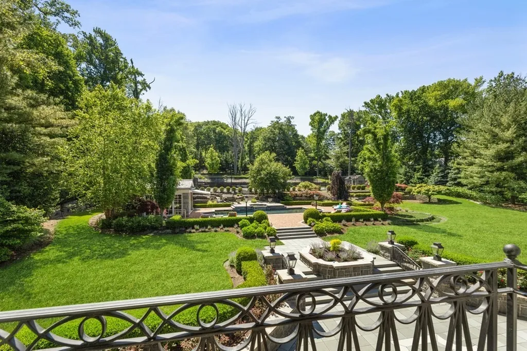 363 Lydecker Street Home in Englewood, New Jersey. This magnificent estate captivates with its stunning granite stone exterior, slate roof, and copper gutters. Inside, indulge in opulent amenities including a Christopher Peacock kitchen, media room, and library with an attached 5-car garage gallery. The home features a complete Crestron home automation and security system, a 3000-bottle wine cellar, elevator, and 9 fireplaces.