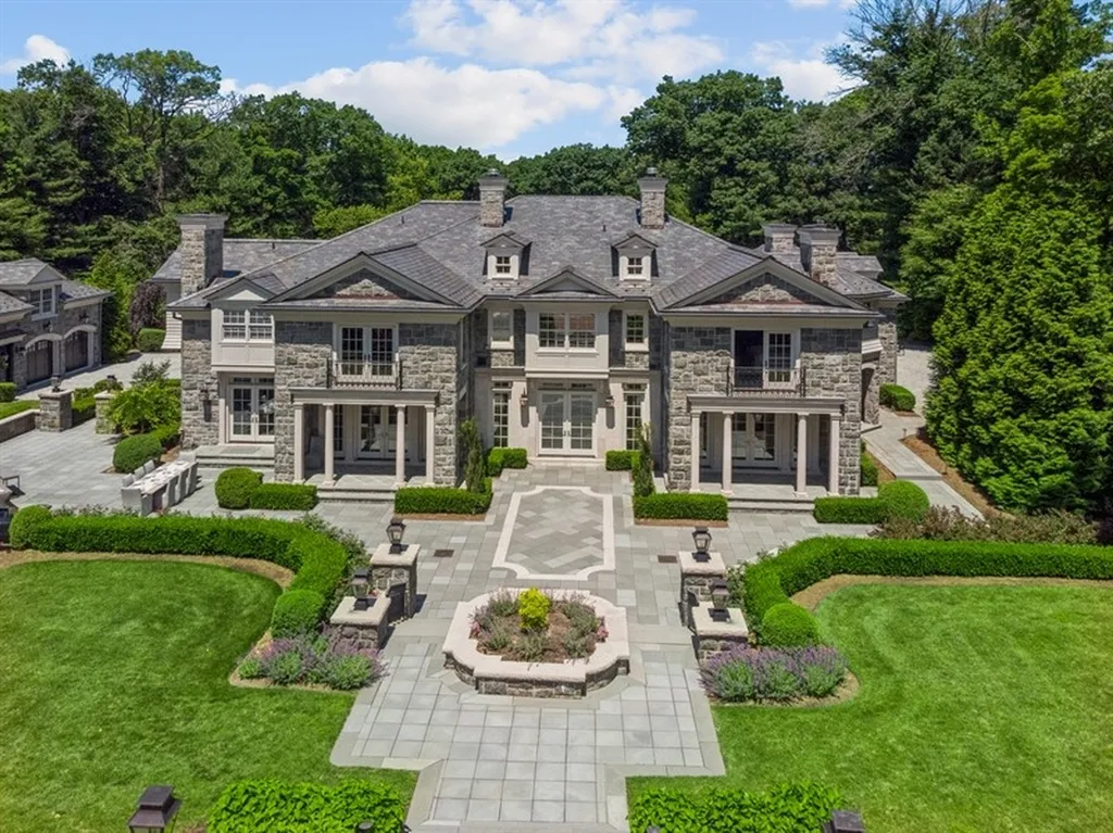 363 Lydecker Street Home in Englewood, New Jersey. This magnificent estate captivates with its stunning granite stone exterior, slate roof, and copper gutters. Inside, indulge in opulent amenities including a Christopher Peacock kitchen, media room, and library with an attached 5-car garage gallery. The home features a complete Crestron home automation and security system, a 3000-bottle wine cellar, elevator, and 9 fireplaces.