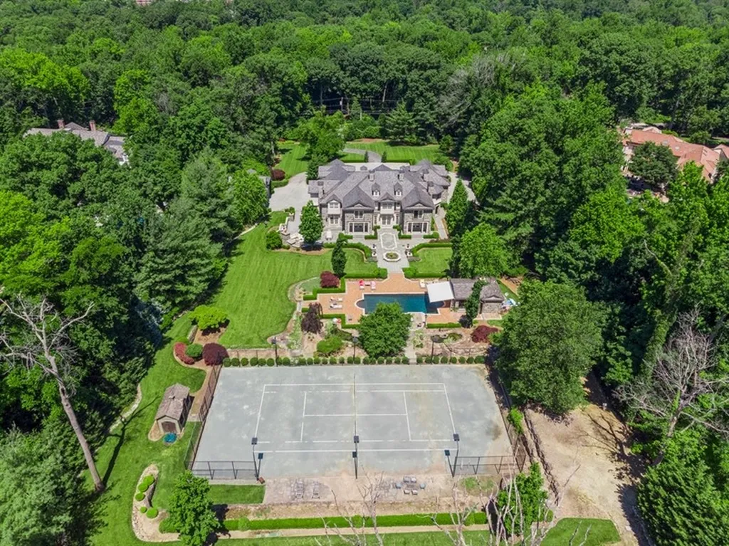 363 Lydecker Street Home in Englewood, New Jersey. This magnificent estate captivates with its stunning granite stone exterior, slate roof, and copper gutters. Inside, indulge in opulent amenities including a Christopher Peacock kitchen, media room, and library with an attached 5-car garage gallery. The home features a complete Crestron home automation and security system, a 3000-bottle wine cellar, elevator, and 9 fireplaces.