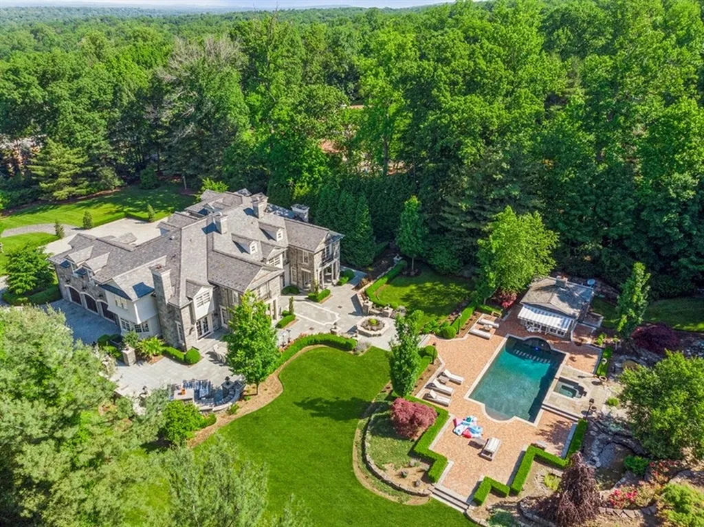 363 Lydecker Street Home in Englewood, New Jersey. This magnificent estate captivates with its stunning granite stone exterior, slate roof, and copper gutters. Inside, indulge in opulent amenities including a Christopher Peacock kitchen, media room, and library with an attached 5-car garage gallery. The home features a complete Crestron home automation and security system, a 3000-bottle wine cellar, elevator, and 9 fireplaces.
