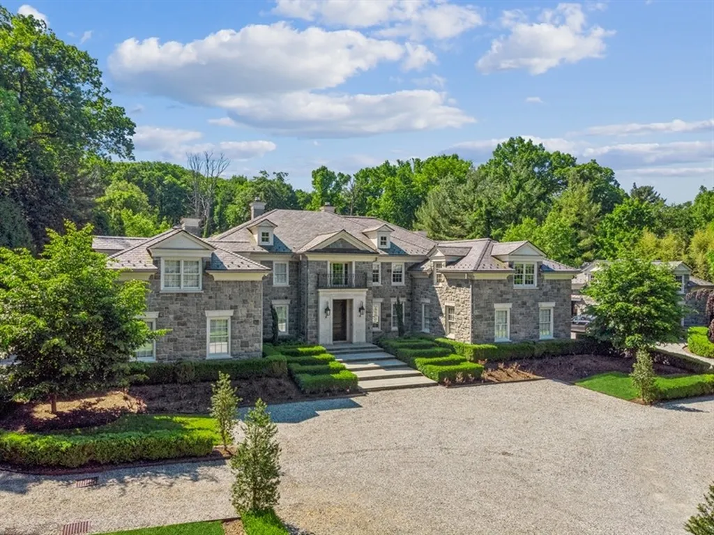 363 Lydecker Street Home in Englewood, New Jersey. This magnificent estate captivates with its stunning granite stone exterior, slate roof, and copper gutters. Inside, indulge in opulent amenities including a Christopher Peacock kitchen, media room, and library with an attached 5-car garage gallery. The home features a complete Crestron home automation and security system, a 3000-bottle wine cellar, elevator, and 9 fireplaces.