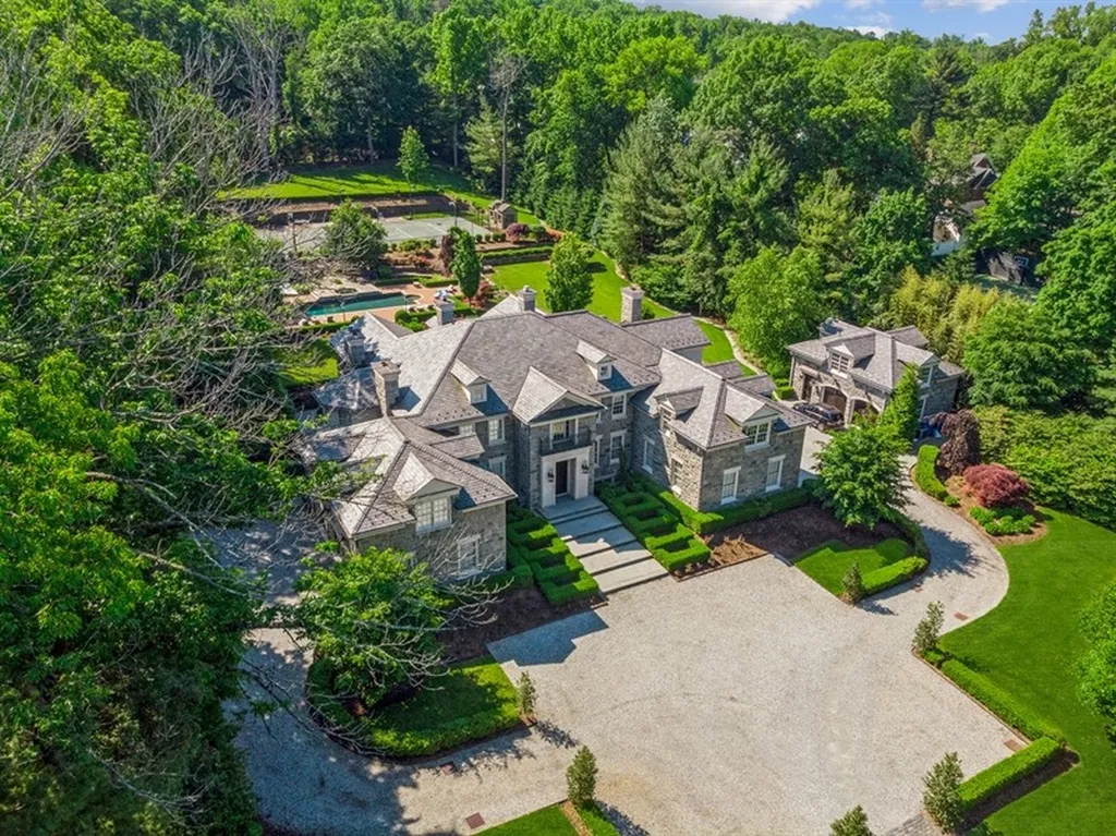363 Lydecker Street Home in Englewood, New Jersey. This magnificent estate captivates with its stunning granite stone exterior, slate roof, and copper gutters. Inside, indulge in opulent amenities including a Christopher Peacock kitchen, media room, and library with an attached 5-car garage gallery. The home features a complete Crestron home automation and security system, a 3000-bottle wine cellar, elevator, and 9 fireplaces.