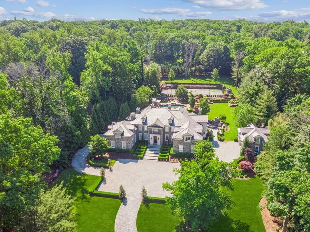363 Lydecker Street Home in Englewood, New Jersey. This magnificent estate captivates with its stunning granite stone exterior, slate roof, and copper gutters. Inside, indulge in opulent amenities including a Christopher Peacock kitchen, media room, and library with an attached 5-car garage gallery. The home features a complete Crestron home automation and security system, a 3000-bottle wine cellar, elevator, and 9 fireplaces.