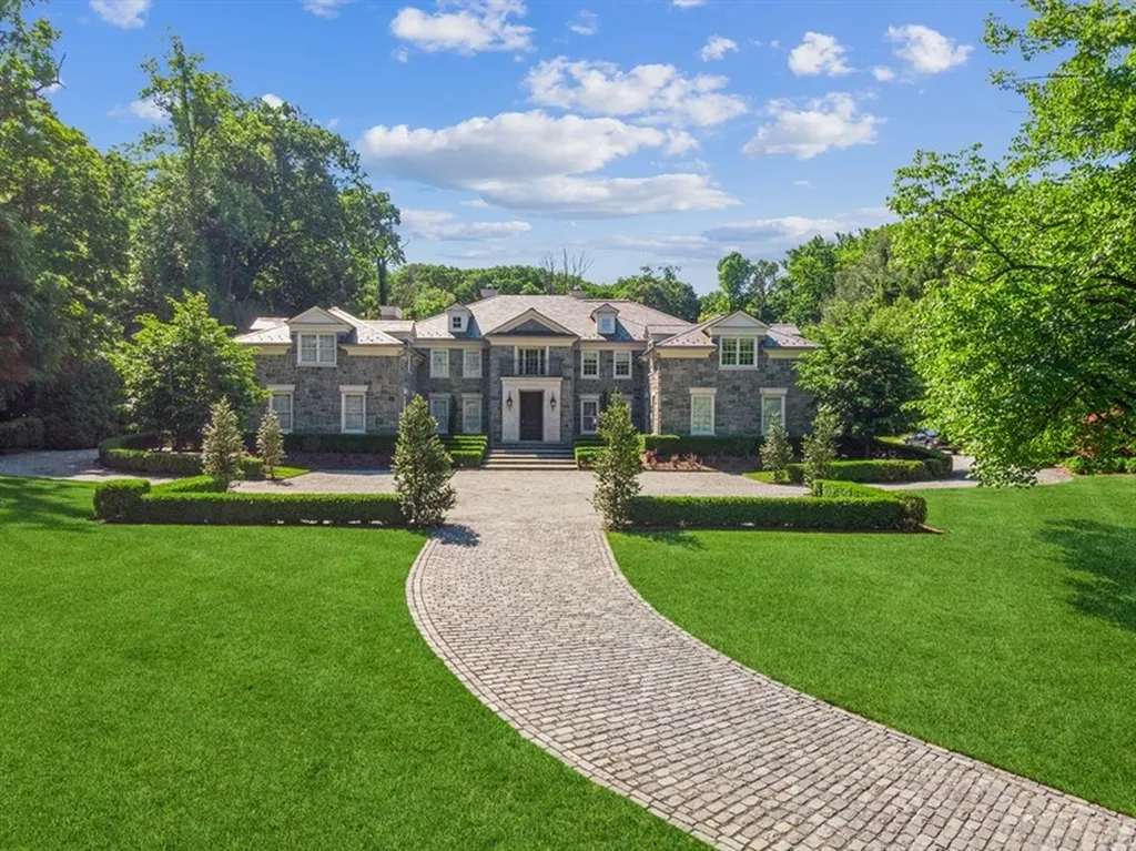 363 Lydecker Street Home in Englewood, New Jersey. This magnificent estate captivates with its stunning granite stone exterior, slate roof, and copper gutters. Inside, indulge in opulent amenities including a Christopher Peacock kitchen, media room, and library with an attached 5-car garage gallery. The home features a complete Crestron home automation and security system, a 3000-bottle wine cellar, elevator, and 9 fireplaces.
