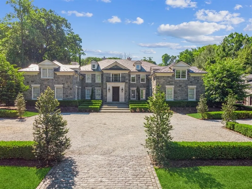363 Lydecker Street Home in Englewood, New Jersey. This magnificent estate captivates with its stunning granite stone exterior, slate roof, and copper gutters. Inside, indulge in opulent amenities including a Christopher Peacock kitchen, media room, and library with an attached 5-car garage gallery. The home features a complete Crestron home automation and security system, a 3000-bottle wine cellar, elevator, and 9 fireplaces.