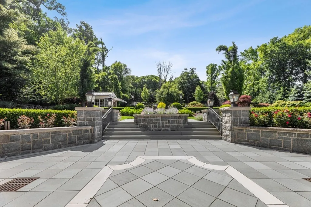 363 Lydecker Street Home in Englewood, New Jersey. This magnificent estate captivates with its stunning granite stone exterior, slate roof, and copper gutters. Inside, indulge in opulent amenities including a Christopher Peacock kitchen, media room, and library with an attached 5-car garage gallery. The home features a complete Crestron home automation and security system, a 3000-bottle wine cellar, elevator, and 9 fireplaces.