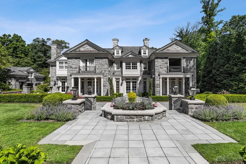 363 Lydecker Street Home in Englewood, New Jersey. This magnificent estate captivates with its stunning granite stone exterior, slate roof, and copper gutters. Inside, indulge in opulent amenities including a Christopher Peacock kitchen, media room, and library with an attached 5-car garage gallery. The home features a complete Crestron home automation and security system, a 3000-bottle wine cellar, elevator, and 9 fireplaces.