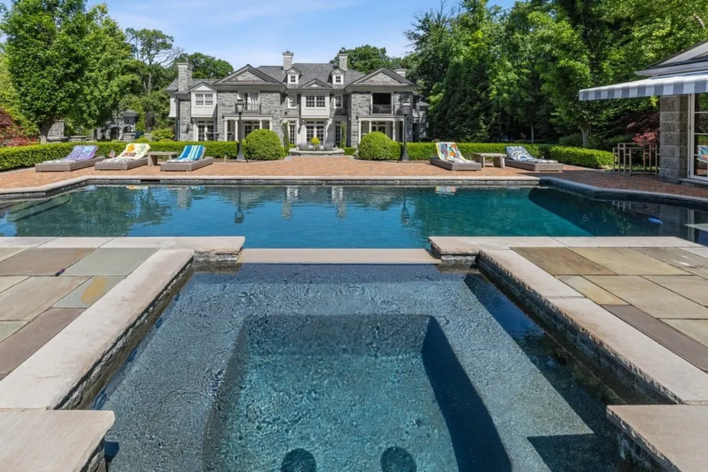 363 Lydecker Street Home in Englewood, New Jersey. This magnificent estate captivates with its stunning granite stone exterior, slate roof, and copper gutters. Inside, indulge in opulent amenities including a Christopher Peacock kitchen, media room, and library with an attached 5-car garage gallery. The home features a complete Crestron home automation and security system, a 3000-bottle wine cellar, elevator, and 9 fireplaces.
