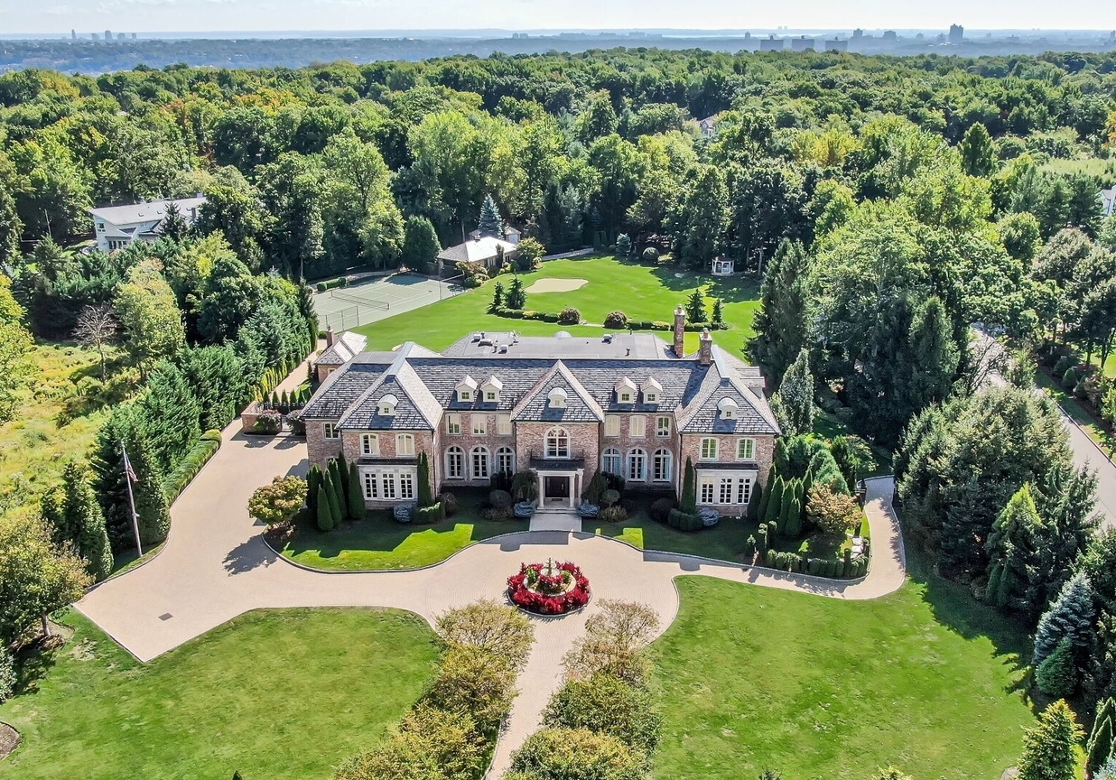4 Stone Tower Drive Home in Alpine, New Jersey. Discover the epitome of luxury living at the majestic Alpine estate, one of the finest homes in Northern Bergen County. Set on 4 gated manicured acres in Rio Vista, this impeccably designed manor by James Paragono showcases architectural excellence and meticulous craftsmanship. With 22,782 square feet of opulent living space spread across 4 levels, this estate boasts 12' ceilings, luxurious amenities, and breathtaking features, including a pool, cabana, tennis court, guest house, and putting green. The residence offers garage parking for 8 cars, an elevator servicing all floors, 25 rooms, a new Salerno kitchen, 8 bedrooms, 9 full and 3 half baths, bowling alleys, a home theater, a commercial generator, and state-of-the-art high-efficiency furnaces.