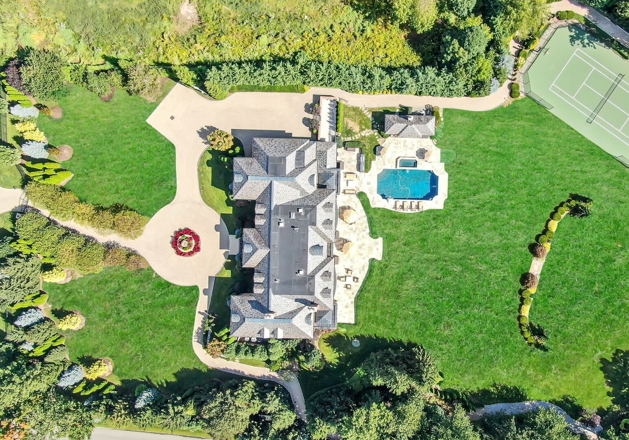 4 Stone Tower Drive Home in Alpine, New Jersey. Discover the epitome of luxury living at the majestic Alpine estate, one of the finest homes in Northern Bergen County. Set on 4 gated manicured acres in Rio Vista, this impeccably designed manor by James Paragono showcases architectural excellence and meticulous craftsmanship. With 22,782 square feet of opulent living space spread across 4 levels, this estate boasts 12' ceilings, luxurious amenities, and breathtaking features, including a pool, cabana, tennis court, guest house, and putting green. The residence offers garage parking for 8 cars, an elevator servicing all floors, 25 rooms, a new Salerno kitchen, 8 bedrooms, 9 full and 3 half baths, bowling alleys, a home theater, a commercial generator, and state-of-the-art high-efficiency furnaces.