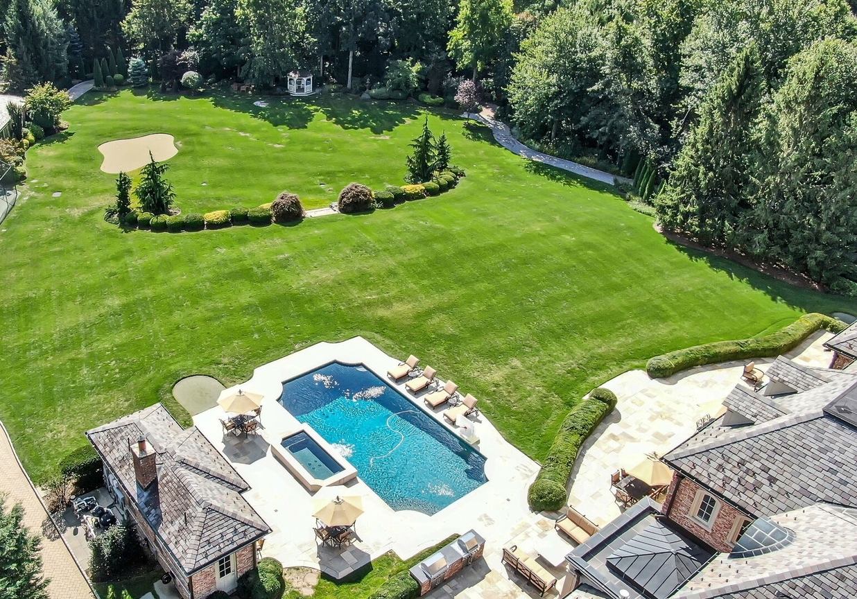 4 Stone Tower Drive Home in Alpine, New Jersey. Discover the epitome of luxury living at the majestic Alpine estate, one of the finest homes in Northern Bergen County. Set on 4 gated manicured acres in Rio Vista, this impeccably designed manor by James Paragono showcases architectural excellence and meticulous craftsmanship. With 22,782 square feet of opulent living space spread across 4 levels, this estate boasts 12' ceilings, luxurious amenities, and breathtaking features, including a pool, cabana, tennis court, guest house, and putting green. The residence offers garage parking for 8 cars, an elevator servicing all floors, 25 rooms, a new Salerno kitchen, 8 bedrooms, 9 full and 3 half baths, bowling alleys, a home theater, a commercial generator, and state-of-the-art high-efficiency furnaces.