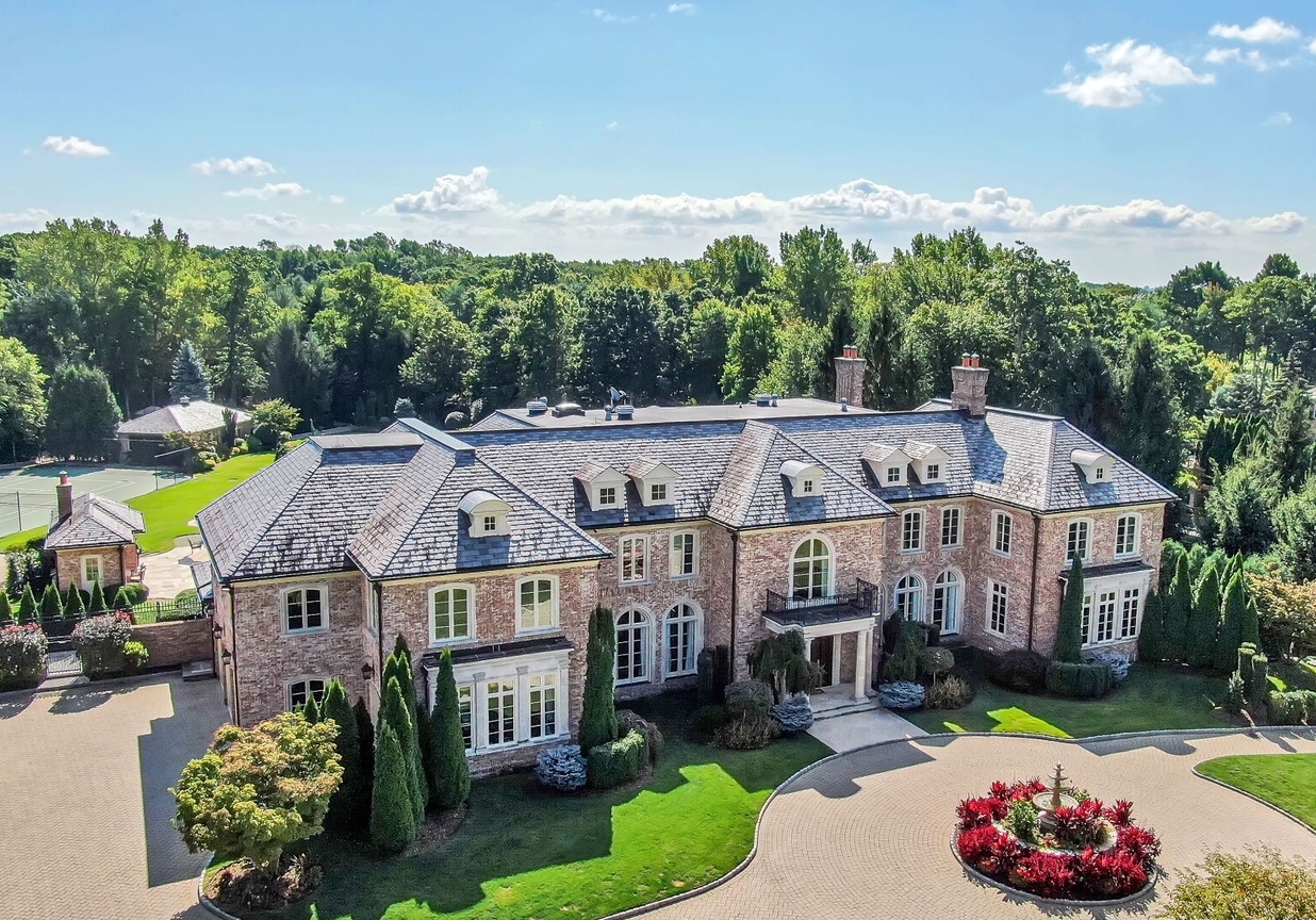 4 Stone Tower Drive Home in Alpine, New Jersey. Discover the epitome of luxury living at the majestic Alpine estate, one of the finest homes in Northern Bergen County. Set on 4 gated manicured acres in Rio Vista, this impeccably designed manor by James Paragono showcases architectural excellence and meticulous craftsmanship. With 22,782 square feet of opulent living space spread across 4 levels, this estate boasts 12' ceilings, luxurious amenities, and breathtaking features, including a pool, cabana, tennis court, guest house, and putting green. The residence offers garage parking for 8 cars, an elevator servicing all floors, 25 rooms, a new Salerno kitchen, 8 bedrooms, 9 full and 3 half baths, bowling alleys, a home theater, a commercial generator, and state-of-the-art high-efficiency furnaces.