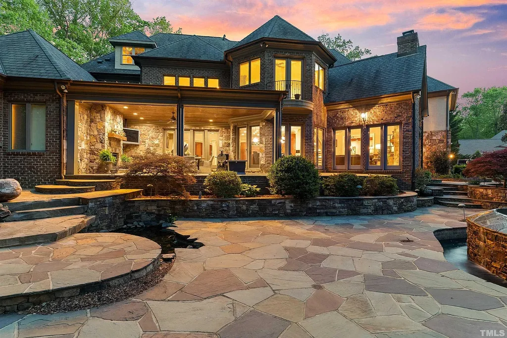 6040 Over Hadden Court Home in Raleigh, North Carolina. Indulge in the epitome of serenity and luxury at the prestigious Don Collins Estate. Nestled on 1.69 acres and embraced by the tranquil beauty of the Falls Lake wooded buffer, this remarkable residence offers an exquisite escape. Immerse yourself in timeless elegance, from the grand entrance with its stunning barreled ceiling to the imported stone accents, cathedral, coffered, and vaulted ceilings, travertine tile, and Brazilian cherry hardwood floors throughout the main level.