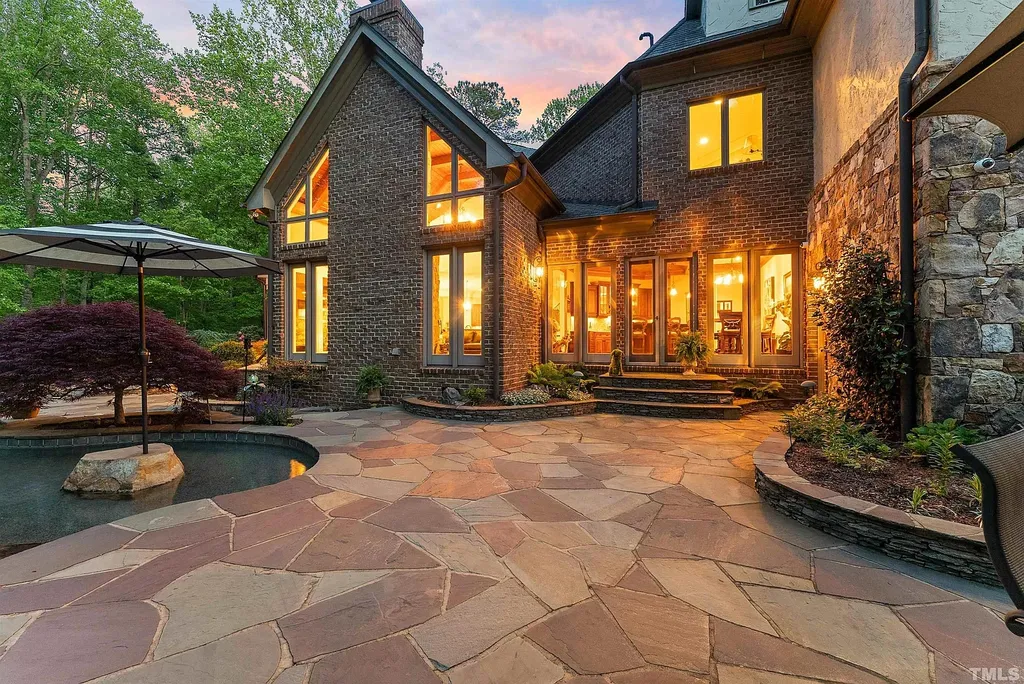 6040 Over Hadden Court Home in Raleigh, North Carolina. Indulge in the epitome of serenity and luxury at the prestigious Don Collins Estate. Nestled on 1.69 acres and embraced by the tranquil beauty of the Falls Lake wooded buffer, this remarkable residence offers an exquisite escape. Immerse yourself in timeless elegance, from the grand entrance with its stunning barreled ceiling to the imported stone accents, cathedral, coffered, and vaulted ceilings, travertine tile, and Brazilian cherry hardwood floors throughout the main level.