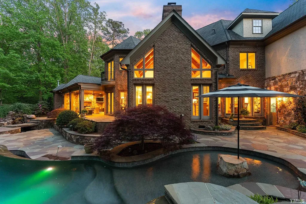 6040 Over Hadden Court Home in Raleigh, North Carolina. Indulge in the epitome of serenity and luxury at the prestigious Don Collins Estate. Nestled on 1.69 acres and embraced by the tranquil beauty of the Falls Lake wooded buffer, this remarkable residence offers an exquisite escape. Immerse yourself in timeless elegance, from the grand entrance with its stunning barreled ceiling to the imported stone accents, cathedral, coffered, and vaulted ceilings, travertine tile, and Brazilian cherry hardwood floors throughout the main level.