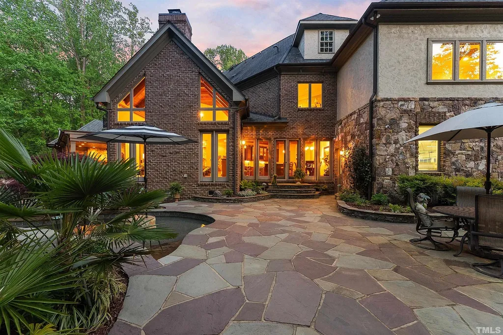 6040 Over Hadden Court Home in Raleigh, North Carolina. Indulge in the epitome of serenity and luxury at the prestigious Don Collins Estate. Nestled on 1.69 acres and embraced by the tranquil beauty of the Falls Lake wooded buffer, this remarkable residence offers an exquisite escape. Immerse yourself in timeless elegance, from the grand entrance with its stunning barreled ceiling to the imported stone accents, cathedral, coffered, and vaulted ceilings, travertine tile, and Brazilian cherry hardwood floors throughout the main level.