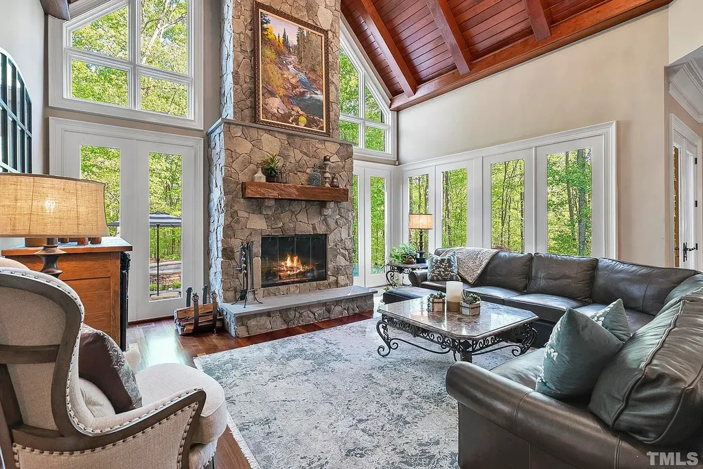 6040 Over Hadden Court Home in Raleigh, North Carolina. Indulge in the epitome of serenity and luxury at the prestigious Don Collins Estate. Nestled on 1.69 acres and embraced by the tranquil beauty of the Falls Lake wooded buffer, this remarkable residence offers an exquisite escape. Immerse yourself in timeless elegance, from the grand entrance with its stunning barreled ceiling to the imported stone accents, cathedral, coffered, and vaulted ceilings, travertine tile, and Brazilian cherry hardwood floors throughout the main level.