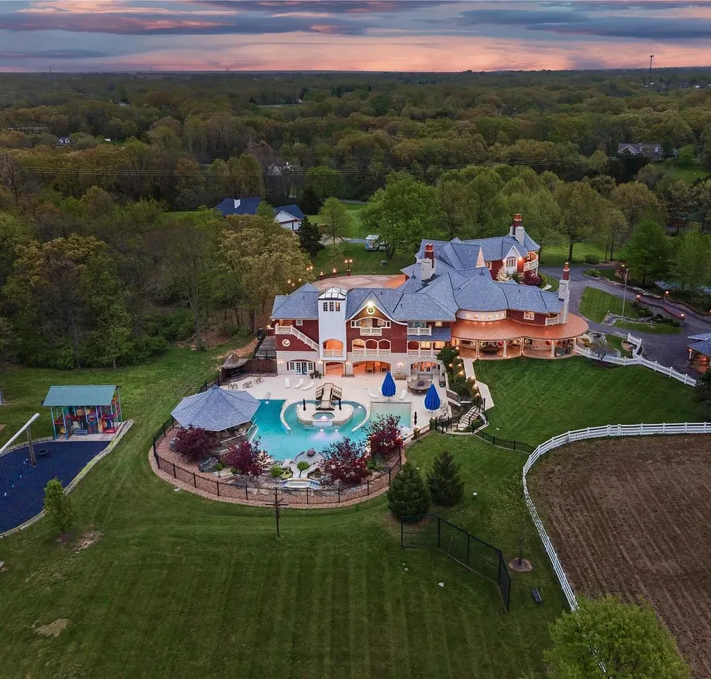 7 Hillside Court Home in Wentzville, Missouri. Prepare for a life-changing experience in this remarkable home that transcends conventional expectations. Embrace the embrace over 20,000 sq. ft. of "Luxury Meant to be Lived In," meticulously designed to cater to multigenerational families, offering abundant space for all. Situated on a vast 20+ acre property (expandable up to 130 acres), this estate presents a plethora of amenities including stables, a sports field, playground, Ferris wheel, event/sports venue, raised bed gardens, and a resort-worthy pool featuring racing slides, a swim-up bar, lazy river, waterfall-covered grotto, dive board, and a zero-edge entry.