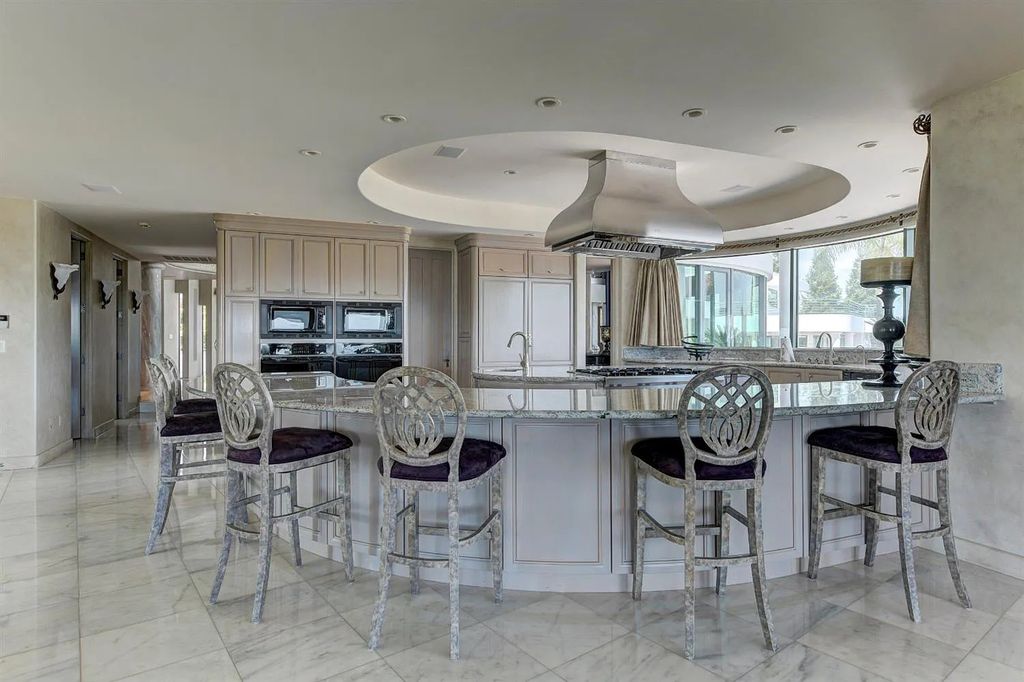 9125 Vista De Lago Court Home in Granite Bay, California. This grand estate is located at the highest point of Los Lagos, providing breathtaking views of Folsom Lake, the Sierra Nevada Mountains, and the Sacramento skyline. The main house boasts over 11,500 square feet while the guest house offers an additional 5,200 square feet.