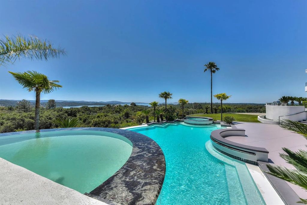 9125 Vista De Lago Court Home in Granite Bay, California. This grand estate is located at the highest point of Los Lagos, providing breathtaking views of Folsom Lake, the Sierra Nevada Mountains, and the Sacramento skyline. The main house boasts over 11,500 square feet while the guest house offers an additional 5,200 square feet.