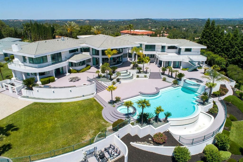 9125 Vista De Lago Court Home in Granite Bay, California. This grand estate is located at the highest point of Los Lagos, providing breathtaking views of Folsom Lake, the Sierra Nevada Mountains, and the Sacramento skyline. The main house boasts over 11,500 square feet while the guest house offers an additional 5,200 square feet.