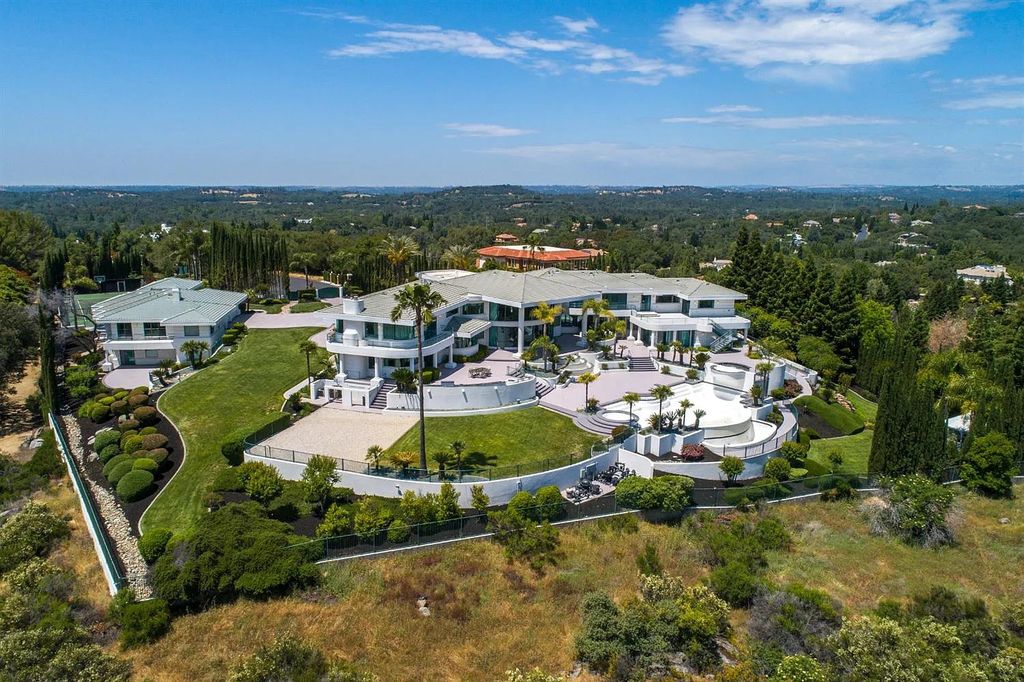9125 Vista De Lago Court Home in Granite Bay, California. This grand estate is located at the highest point of Los Lagos, providing breathtaking views of Folsom Lake, the Sierra Nevada Mountains, and the Sacramento skyline. The main house boasts over 11,500 square feet while the guest house offers an additional 5,200 square feet.