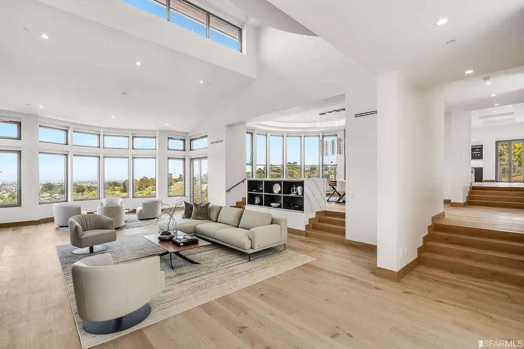 165 Woodridge Road Home in Hillsborough, California. Situated on 2.19 acres, this brand new state-of-the-art construction in Northern California boasts unobstructed, panoramic views as far as the eye can see. The architectural marvel features 26-ft high curved ceilings, rounded walls, and floor-to-ceiling windows, bathing the interior in natural light and showcasing breathtaking 180-degree bay and canyon vistas. Step onto the stunning limestone terrace, where a curved pool with a dancing water feature, spa, built-in Kalamazoo bbq station, outdoor shower, and access to a luxurious 2-bedroom, 2-bath guest house await. 