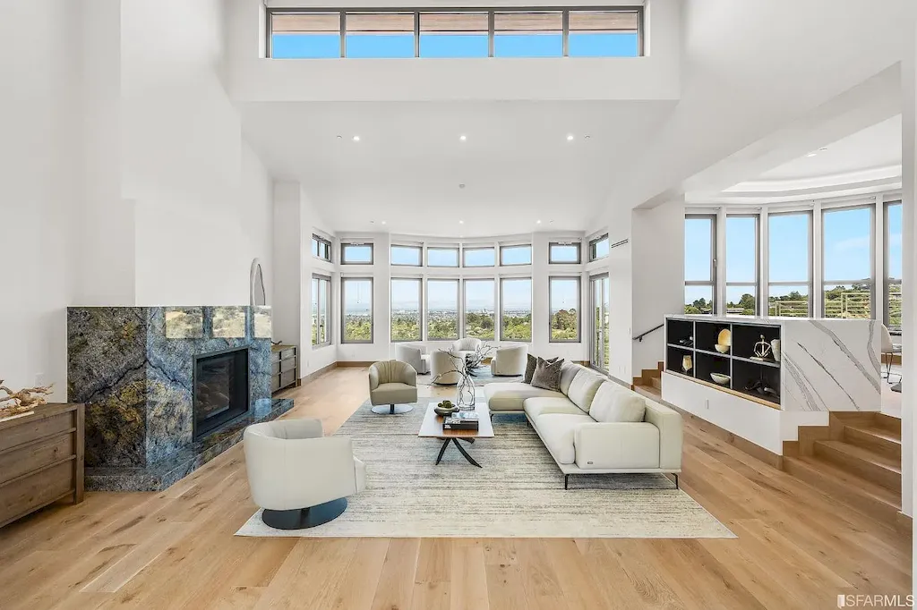 165 Woodridge Road Home in Hillsborough, California. Situated on 2.19 acres, this brand new state-of-the-art construction in Northern California boasts unobstructed, panoramic views as far as the eye can see. The architectural marvel features 26-ft high curved ceilings, rounded walls, and floor-to-ceiling windows, bathing the interior in natural light and showcasing breathtaking 180-degree bay and canyon vistas. Step onto the stunning limestone terrace, where a curved pool with a dancing water feature, spa, built-in Kalamazoo bbq station, outdoor shower, and access to a luxurious 2-bedroom, 2-bath guest house await. 