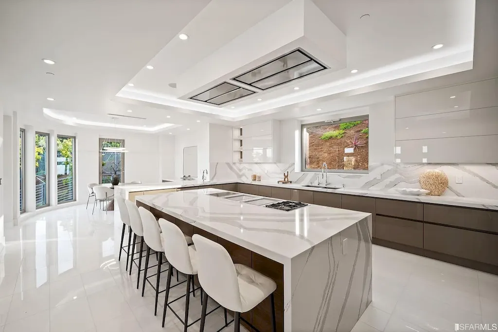 165 Woodridge Road Home in Hillsborough, California. Situated on 2.19 acres, this brand new state-of-the-art construction in Northern California boasts unobstructed, panoramic views as far as the eye can see. The architectural marvel features 26-ft high curved ceilings, rounded walls, and floor-to-ceiling windows, bathing the interior in natural light and showcasing breathtaking 180-degree bay and canyon vistas. Step onto the stunning limestone terrace, where a curved pool with a dancing water feature, spa, built-in Kalamazoo bbq station, outdoor shower, and access to a luxurious 2-bedroom, 2-bath guest house await. 