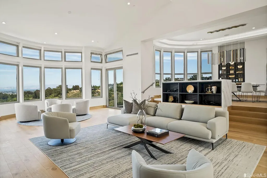 165 Woodridge Road Home in Hillsborough, California. Situated on 2.19 acres, this brand new state-of-the-art construction in Northern California boasts unobstructed, panoramic views as far as the eye can see. The architectural marvel features 26-ft high curved ceilings, rounded walls, and floor-to-ceiling windows, bathing the interior in natural light and showcasing breathtaking 180-degree bay and canyon vistas. Step onto the stunning limestone terrace, where a curved pool with a dancing water feature, spa, built-in Kalamazoo bbq station, outdoor shower, and access to a luxurious 2-bedroom, 2-bath guest house await. 