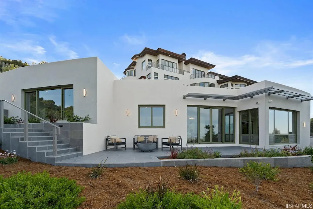 165 Woodridge Road Home in Hillsborough, California. Situated on 2.19 acres, this brand new state-of-the-art construction in Northern California boasts unobstructed, panoramic views as far as the eye can see. The architectural marvel features 26-ft high curved ceilings, rounded walls, and floor-to-ceiling windows, bathing the interior in natural light and showcasing breathtaking 180-degree bay and canyon vistas. Step onto the stunning limestone terrace, where a curved pool with a dancing water feature, spa, built-in Kalamazoo bbq station, outdoor shower, and access to a luxurious 2-bedroom, 2-bath guest house await. 