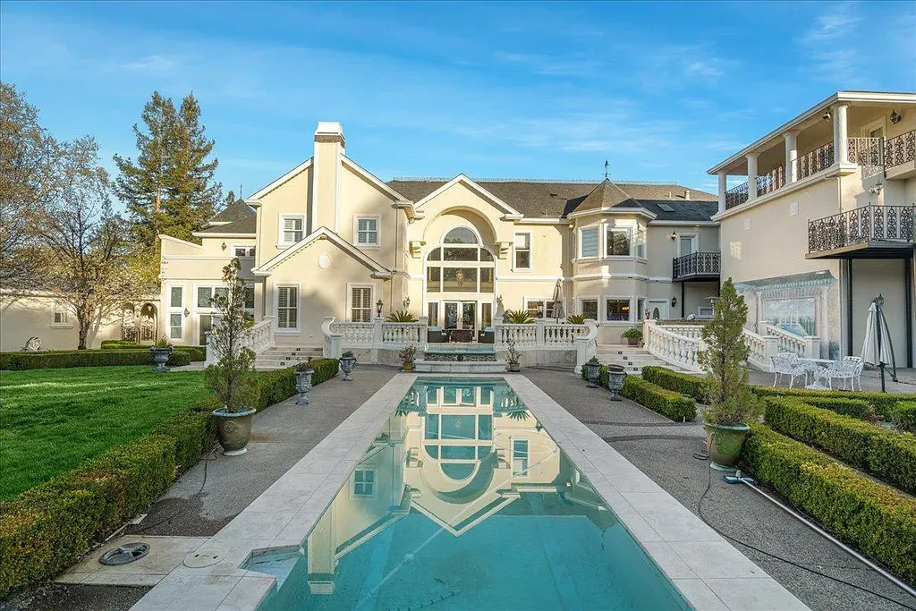 18911 Decatur Road Home in Los Gatos, California. This extraordinary estate in Monte Sereno has undergone a remarkable transformation with a remodel exceeding $5 million. It epitomizes the grandeur of a sprawling European luxury property, occupying a pristine and expansive 1.37-acre flat lot. This extraordinary estate in Monte Sereno has undergone a remarkable transformation with a remodel exceeding $5 million. It epitomizes the grandeur of a sprawling European luxury property, occupying a pristine and expansive 1.37-acre flat lot. The impressive slate roof structure encompasses approximately 17,000 square feet, boasting 10 bedrooms, 8 bathrooms, a separate guest house, an apartment, a 10-car garage, an elevator, an underground shooting range, an indoor basketball/racket ball court, a USTA tennis court, a resort-style lap pool, a great room, a home theatre, a bonus room, two formal libraries, and a home gym.
