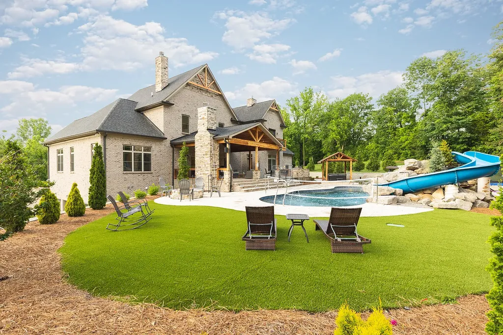 5078 Central Pike Home in Mount Juliet, Tennessee. Discover the epitome of luxury living in this stunning custom home situated on nearly 8 acres in Wilson County. Boasting a spacious floor plan, this residence features 5 bedroom suites, a workout room, a hobby room/office, and an outdoor entertaining area complete with a kitchen, custom pool, hot tub, and fire pit. Step into the indoor kitchen, which showcases leathered granite and quartz countertops, as well as a walk-in pantry. The main level and master bath offer the comfort of heated tile flooring.