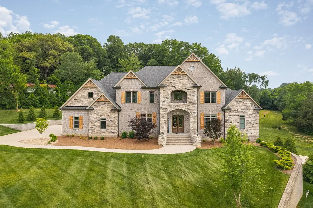 5078 Central Pike Home in Mount Juliet, Tennessee. Discover the epitome of luxury living in this stunning custom home situated on nearly 8 acres in Wilson County. Boasting a spacious floor plan, this residence features 5 bedroom suites, a workout room, a hobby room/office, and an outdoor entertaining area complete with a kitchen, custom pool, hot tub, and fire pit. Step into the indoor kitchen, which showcases leathered granite and quartz countertops, as well as a walk-in pantry. The main level and master bath offer the comfort of heated tile flooring.