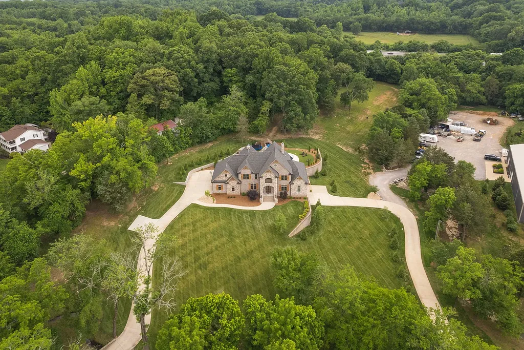 5078 Central Pike Home in Mount Juliet, Tennessee. Discover the epitome of luxury living in this stunning custom home situated on nearly 8 acres in Wilson County. Boasting a spacious floor plan, this residence features 5 bedroom suites, a workout room, a hobby room/office, and an outdoor entertaining area complete with a kitchen, custom pool, hot tub, and fire pit. Step into the indoor kitchen, which showcases leathered granite and quartz countertops, as well as a walk-in pantry. The main level and master bath offer the comfort of heated tile flooring.