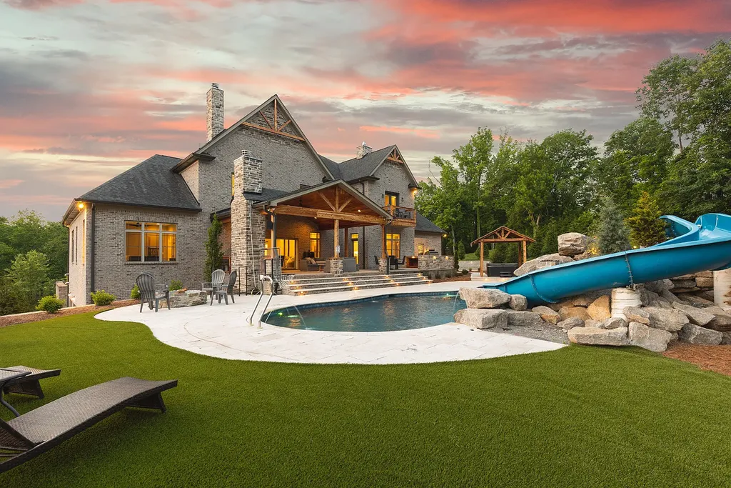 5078 Central Pike Home in Mount Juliet, Tennessee. Discover the epitome of luxury living in this stunning custom home situated on nearly 8 acres in Wilson County. Boasting a spacious floor plan, this residence features 5 bedroom suites, a workout room, a hobby room/office, and an outdoor entertaining area complete with a kitchen, custom pool, hot tub, and fire pit. Step into the indoor kitchen, which showcases leathered granite and quartz countertops, as well as a walk-in pantry. The main level and master bath offer the comfort of heated tile flooring.