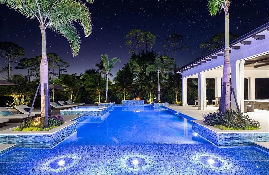 Welcome to 149 Cajeput Drive, Naples, Florida - a newly constructed masterpiece of timeless elegance. This exceptional estate boasts 5 bedrooms, 8 bathrooms, and spans 9,833 square feet.