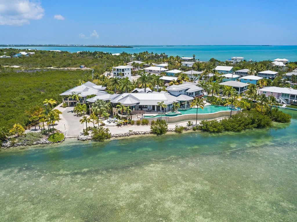 Introducing 1300 Sunset Boulevard, Tarpon Ranch—an elegant private estate in Summerland Key, Florida. Just minutes from Key West, this luxurious property offers relaxed coastal living at its finest. With 6 bedrooms, 8 bathrooms, and 7,720 square feet of living space on a 1.35-acre lot, it's a masterpiece of architectural splendor.