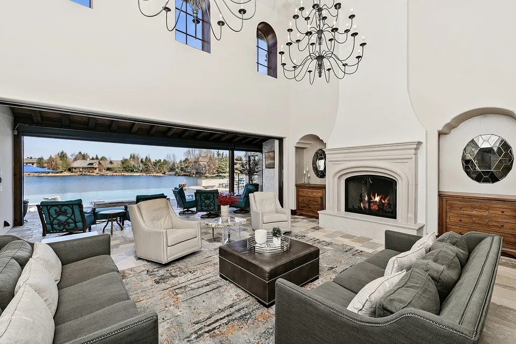 1454 S Heron Pointe Lane Home in Eagle, Idaho. Discover the epitome of luxury and quality in this exceptional Santa Barbara style custom home. Built by renowned Northern Construction and designed by acclaimed architect Trey Hoff, this 1.5-acre waterfront property boasts stunning Spanish Colonial architecture. Step into a world of elegance with an infinity pool, spa, and covered outdoor living area featuring custom sound, heaters, televisions, fireplace, and lighting.