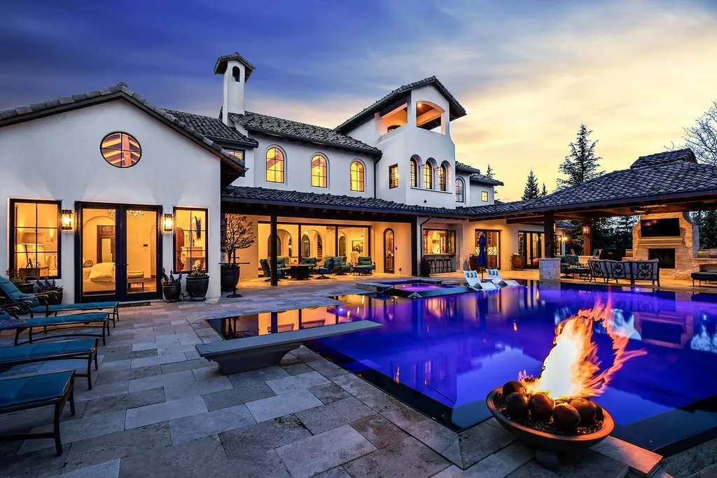 1454 S Heron Pointe Lane Home in Eagle, Idaho. Discover the epitome of luxury and quality in this exceptional Santa Barbara style custom home. Built by renowned Northern Construction and designed by acclaimed architect Trey Hoff, this 1.5-acre waterfront property boasts stunning Spanish Colonial architecture. Step into a world of elegance with an infinity pool, spa, and covered outdoor living area featuring custom sound, heaters, televisions, fireplace, and lighting.