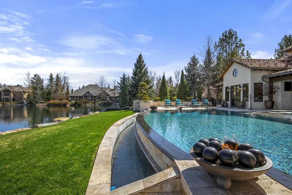 1454 S Heron Pointe Lane Home in Eagle, Idaho. Discover the epitome of luxury and quality in this exceptional Santa Barbara style custom home. Built by renowned Northern Construction and designed by acclaimed architect Trey Hoff, this 1.5-acre waterfront property boasts stunning Spanish Colonial architecture. Step into a world of elegance with an infinity pool, spa, and covered outdoor living area featuring custom sound, heaters, televisions, fireplace, and lighting.