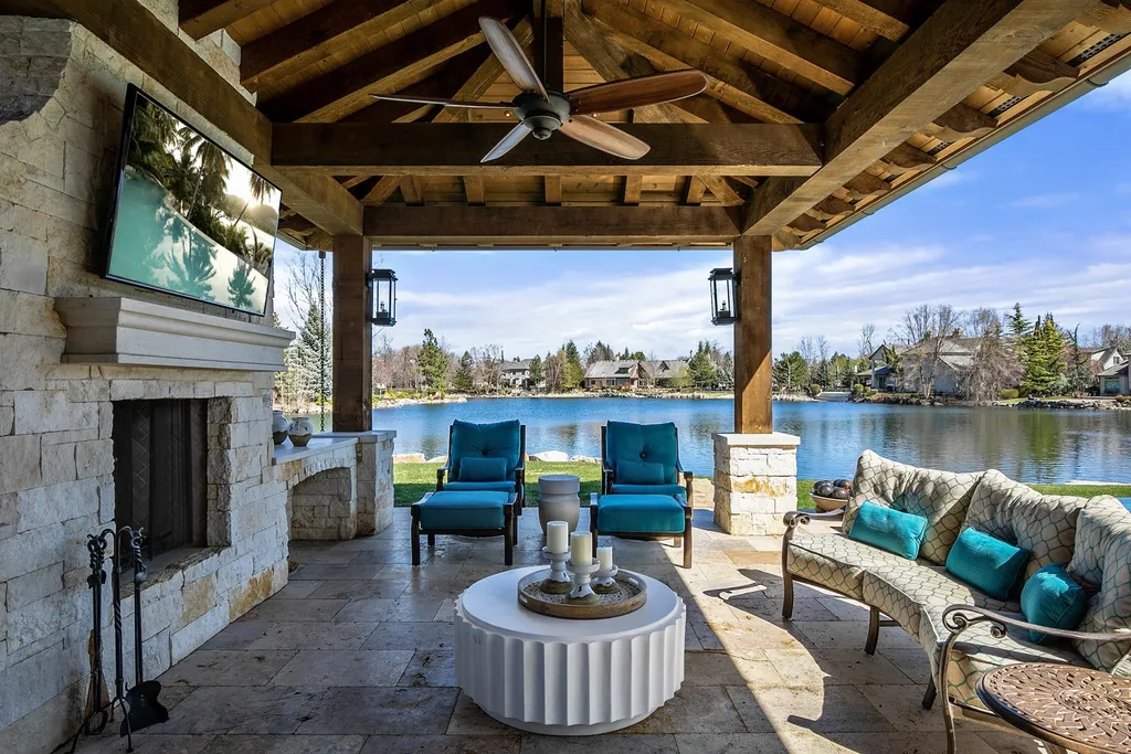 1454 S Heron Pointe Lane Home in Eagle, Idaho. Discover the epitome of luxury and quality in this exceptional Santa Barbara style custom home. Built by renowned Northern Construction and designed by acclaimed architect Trey Hoff, this 1.5-acre waterfront property boasts stunning Spanish Colonial architecture. Step into a world of elegance with an infinity pool, spa, and covered outdoor living area featuring custom sound, heaters, televisions, fireplace, and lighting.