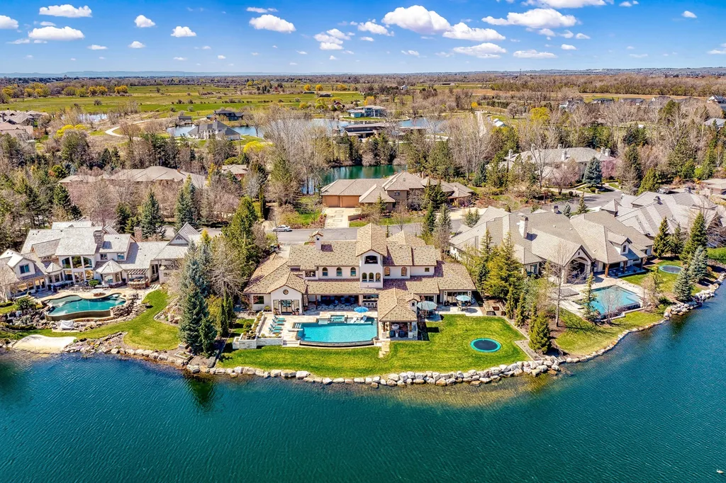 1454 S Heron Pointe Lane Home in Eagle, Idaho. Discover the epitome of luxury and quality in this exceptional Santa Barbara style custom home. Built by renowned Northern Construction and designed by acclaimed architect Trey Hoff, this 1.5-acre waterfront property boasts stunning Spanish Colonial architecture. Step into a world of elegance with an infinity pool, spa, and covered outdoor living area featuring custom sound, heaters, televisions, fireplace, and lighting.