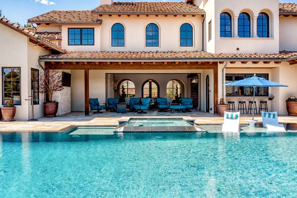 1454 S Heron Pointe Lane Home in Eagle, Idaho. Discover the epitome of luxury and quality in this exceptional Santa Barbara style custom home. Built by renowned Northern Construction and designed by acclaimed architect Trey Hoff, this 1.5-acre waterfront property boasts stunning Spanish Colonial architecture. Step into a world of elegance with an infinity pool, spa, and covered outdoor living area featuring custom sound, heaters, televisions, fireplace, and lighting.