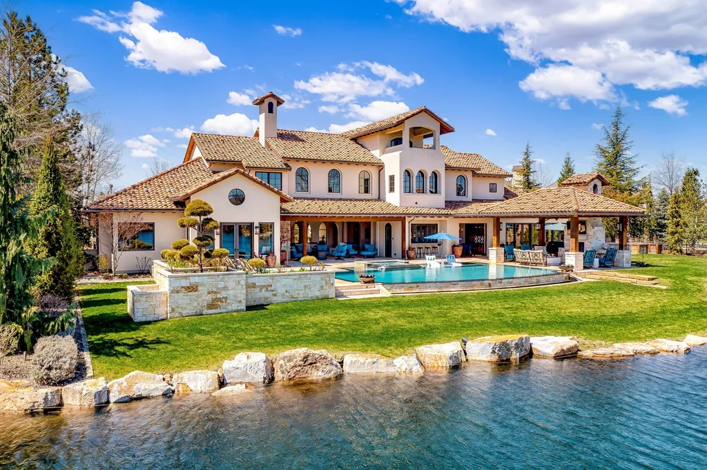 1454 S Heron Pointe Lane Home in Eagle, Idaho. Discover the epitome of luxury and quality in this exceptional Santa Barbara style custom home. Built by renowned Northern Construction and designed by acclaimed architect Trey Hoff, this 1.5-acre waterfront property boasts stunning Spanish Colonial architecture. Step into a world of elegance with an infinity pool, spa, and covered outdoor living area featuring custom sound, heaters, televisions, fireplace, and lighting.