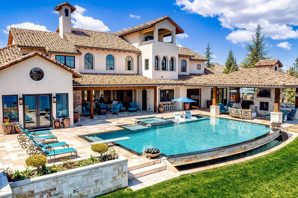 1454 S Heron Pointe Lane Home in Eagle, Idaho. Discover the epitome of luxury and quality in this exceptional Santa Barbara style custom home. Built by renowned Northern Construction and designed by acclaimed architect Trey Hoff, this 1.5-acre waterfront property boasts stunning Spanish Colonial architecture. Step into a world of elegance with an infinity pool, spa, and covered outdoor living area featuring custom sound, heaters, televisions, fireplace, and lighting.